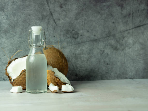 istock fresh refreshing Coconut water in a bottle with an open coconut with white pulp on a concrete background. 1441504470