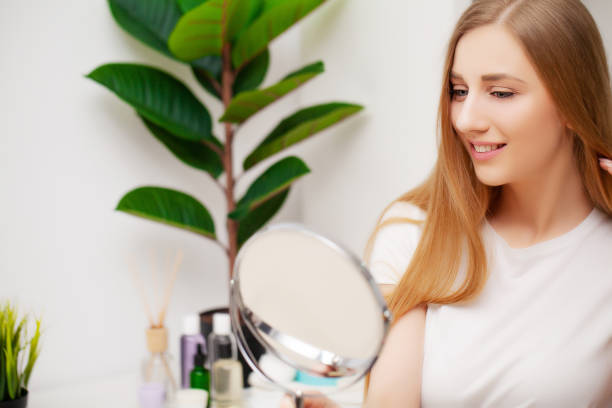 istock Pretty young female looking in the mirror after a shower 1441505465