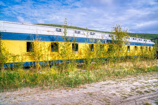 Abandoned and overgrown old railroad passenger car in Alaska