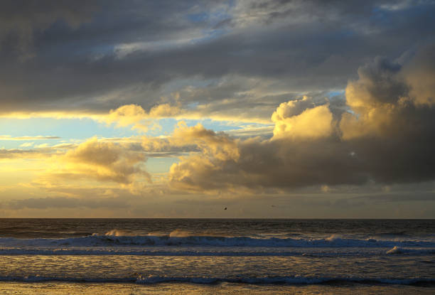 Wide view of sunset, storm clouds and ocean waves off the Central California Coast.Taken at Castroville, California, USA