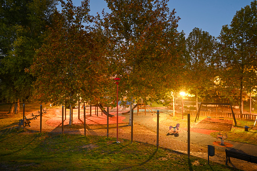 Giardini pubblici con aarco giochi illuminato in autunno