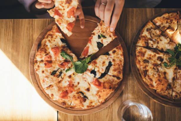 istock Closeup hands taking pizza pieces. 1441511957