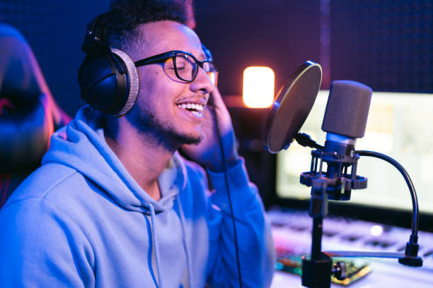 istock Young male singer in recording studio performing in neon lights 1441512197