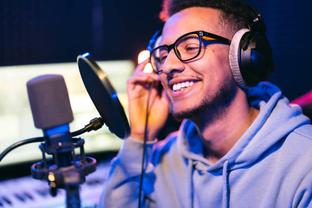 istock Young male singer in recording studio performing in neon lights 1441512214