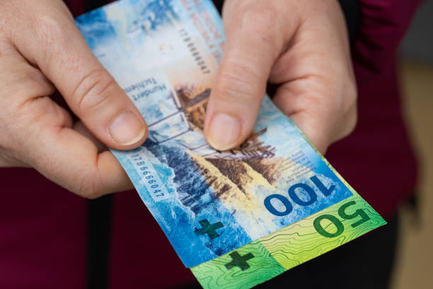 the woman holds swiss money, 100 and 50 franc banknotes - swiss currency franc sign switzerland currency imagens e fotografias de stock