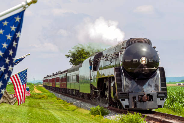 istock A Restored Steam Passenger Train Approaches As American Flags Wave on a Fence 1441519185
