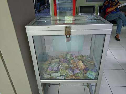 A charity box in a public place where people put money inside it for charity and helping others.