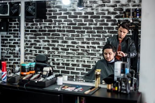 Barber cutting transgender man's hair