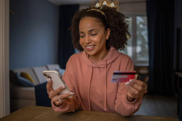 istock Cheerful  woman doing online shopping 1441531564