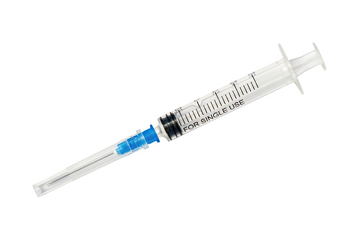 Plastic disposable syringe with protective cap isolated on white background