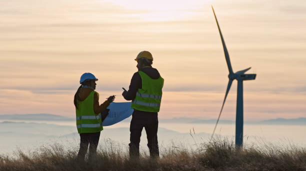 istock Wind energy engineers working in wind farm at dusk. Renewable Energy Systems. Carbon neutrality and sustainable energy. 1441531894
