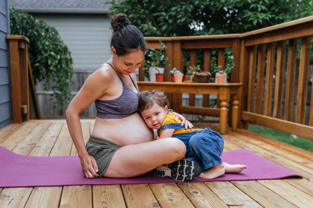 istock Fit pregnant mom exercising with her daughter 1441532327