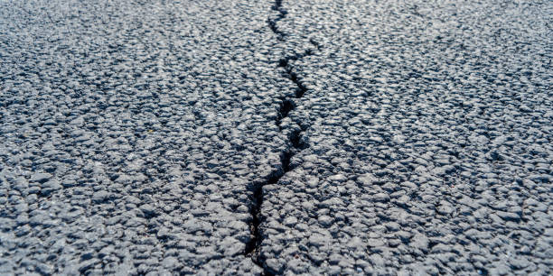 istock terrible crack in the road pavement, close up blurry background 1441533369