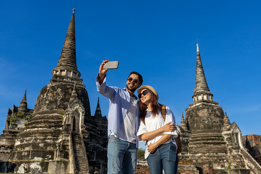 Couple of foreign tourists take selfie photo at Wat Phra Si Sanphet temple, Ayutthaya Thailand, for travel, vacation, holiday, honeymoon and tourism