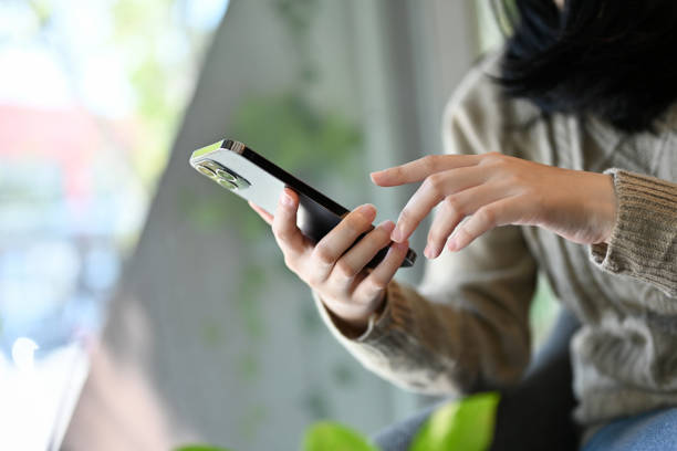 istock Close-up, side view. A female using her smartphone, touching on mobile screen. 1441541768