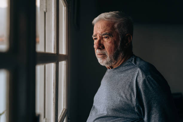 istock Elderly man looking out the window 1441546057