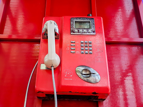 The old red wired telephone in the past, it's like going back to the past where people often used public telephones