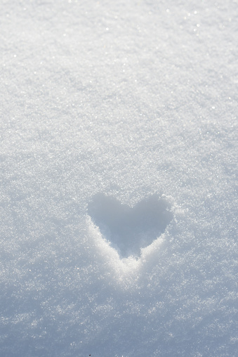 Heart shape painted on white snow background. Frozen heart, snow Valentine, Valentine days postcard background with  copy space