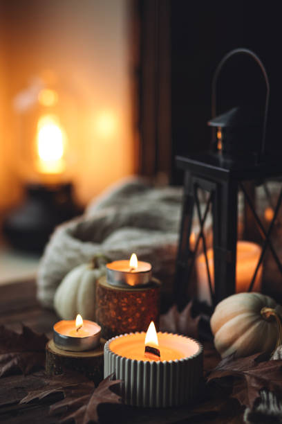 istock Cozy autumn composition with aromatic candle, pumpkins, wool sweater, leaves, cinnamon. Aromatherapy on a grey fall morning, home atmosphere of cosiness and relax. Wooden background close up. 1441550801