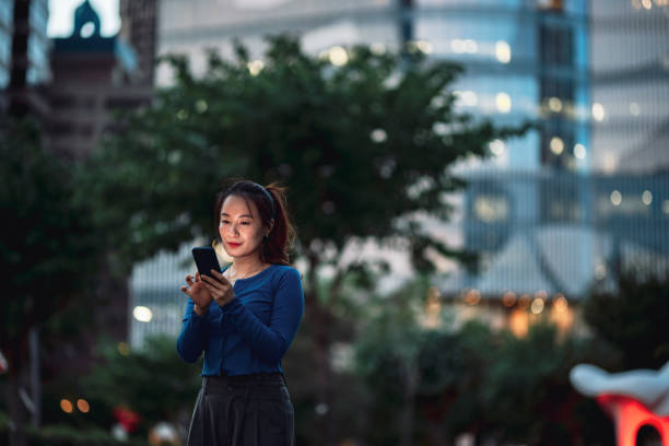 istock Young businesswoman using smartphone in financial district, 1441551797