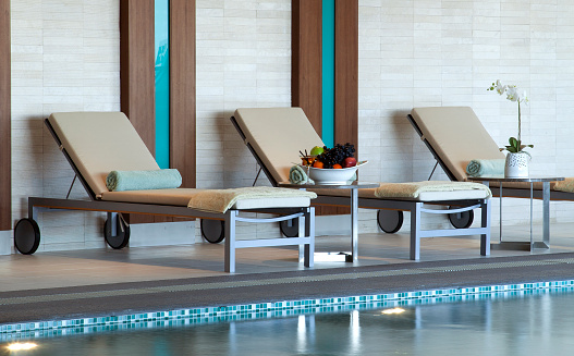 Three Adjustable Lounge Chairs By Swimming Pool