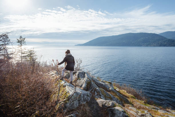 istock Mutliracial Young Woman Examining Seedhead While Exploring Rocky Viewpoint, Autumn 1441562548