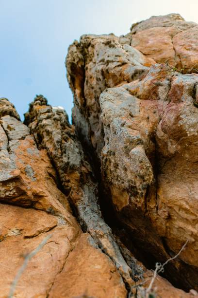 istock Low angle of an orange and gray cliff with cracks during the daytime 1441564607