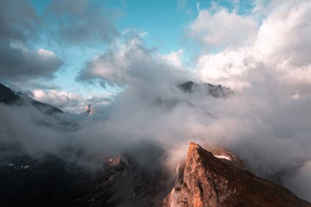 cresta montañosa brumosa al amanecer en oberland bernés, gemmi, suiza - gemmi fotografías e imágenes de stock