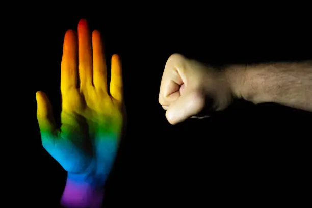 Photo of Hands making a stop and punch gesture on a black background