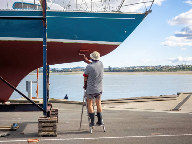 Yacht on dry dock stand being repaired with antifoul. Auckland, New Zealand – May 19, 2021: Yacht on dry dock stand being repaired with antifoul. Auckland, New Zealand - May 13, 2021 hull house stock pictures, royalty-free photos & images