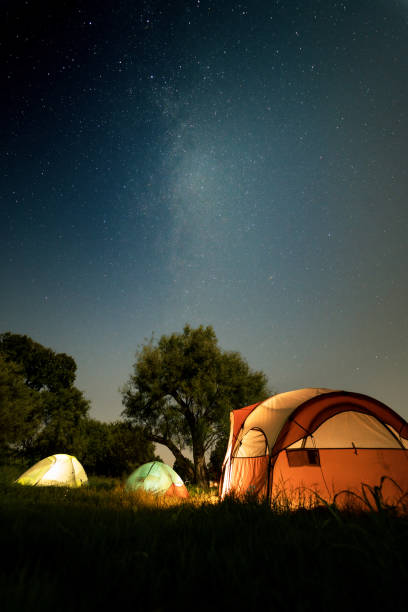 istock Starry night and tents on a green field 1441569313