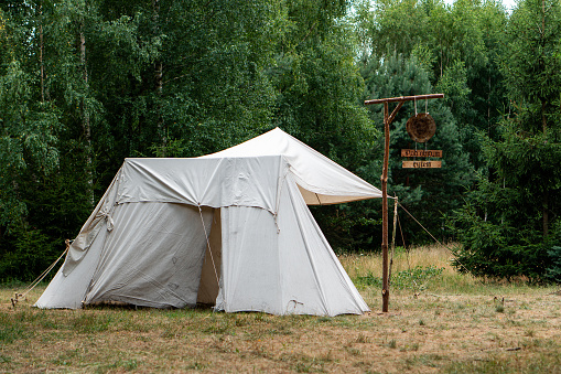 A view of a white tent in a forest