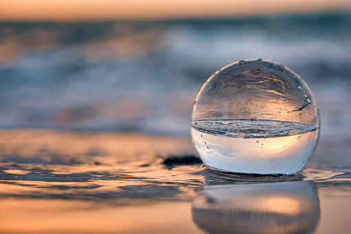 A shallow focus of a crystal Glass ball on beach sunset at sunset time
