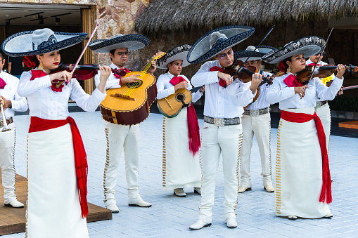 San Francisco, Mexico – January 02, 2022: A beautiful shot of Mariachi musicians band dressed in white playing in the street