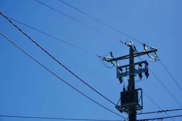 istock Tall metal post with electric wires attached to it under a clear bright blue sky 1441571818
