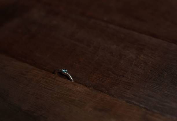 istock A wedding ring with a blue diamond on it between dark color woods 1441572486