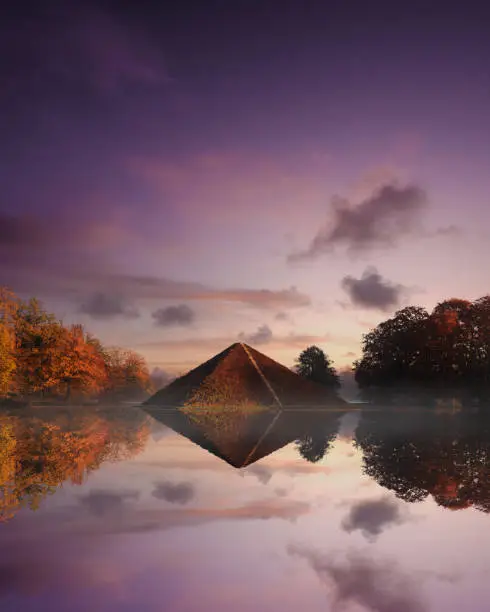 A vertical shot of a pyramid reflected in a pond in the Branitz Park, Cottbus, Germany