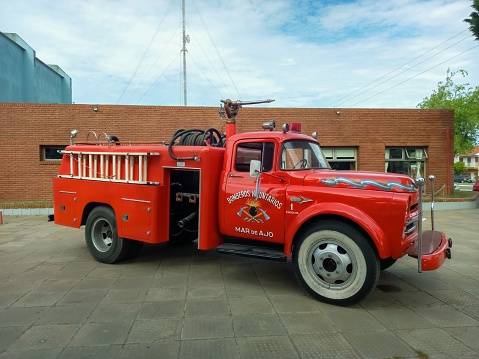 Mar de Ajo, Argentina – October 16, 2022: Old classic red 1950s Chrysler Fargo 500 fire truck pumper tanker outdoors.