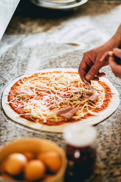 istock Closeup of a man preparing a pizza 1441575121