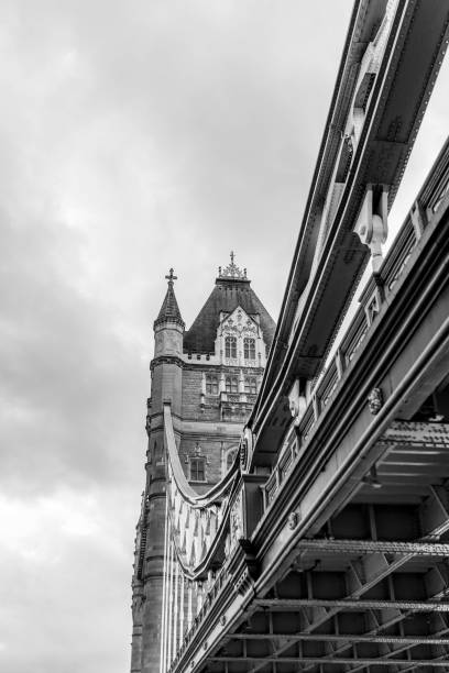 istock Black and white low angle view of Tower bridge with cloudy sky on background 1441576318