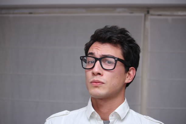Young man wearing blue casual plaid shirt clothes and glasses surprised and shocked with excited face over white background