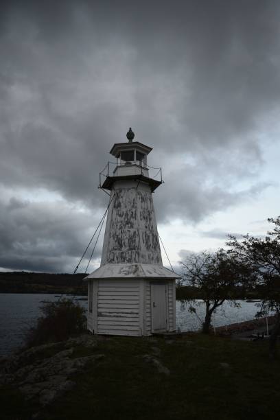 istock Dramatic vertical shot of a lighthouse on a gloomy day with waterscape and dark clouds 1441577559