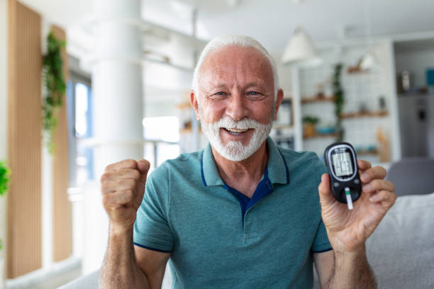 blutzuckertest zu hause. überprüfung des blutzuckerspiegels zu hause. diabetiker überprüfen blutzuckerspiegel. älterer mann, der den blutzuckerspiegel mit blutzuckermessgerät und teststreifen zu hause überprüft - diabetes stock-fotos und bilder