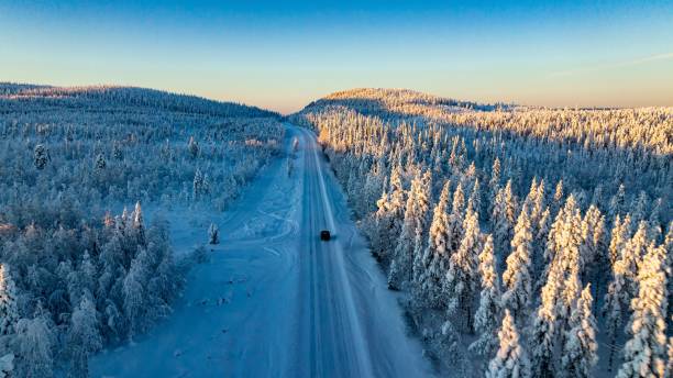 car driving in sunlit, snow covered forest 01