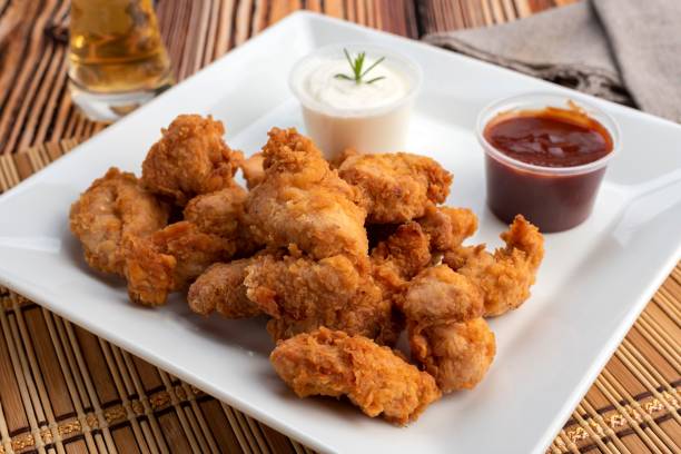 istock Chiken nuggets with white and red sauces on square white plate 1441579955