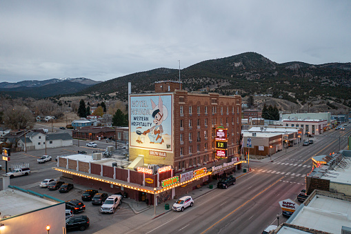 Ely, United States – December 18, 2021: The historic Hotel Nevada building lit up in neon lights as dusk settles on Ely, Nevada.