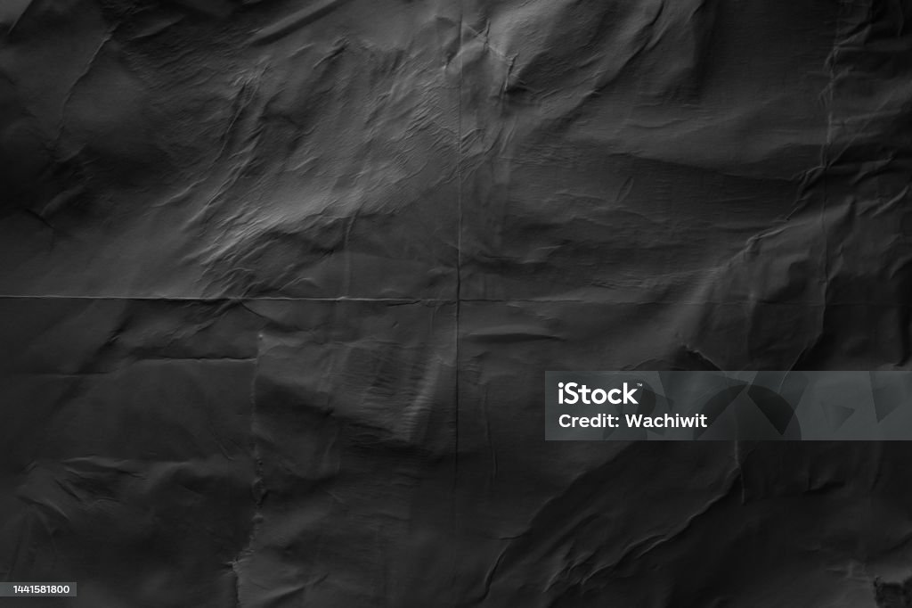 Heavy crumpled black paper texture in low light background Textured Stock Photo