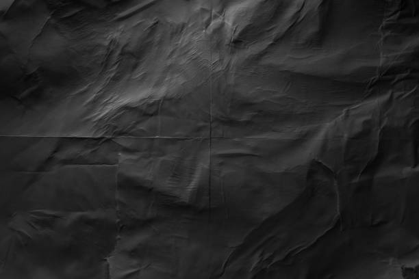 heavy crumpled black paper texture in low light background - paper folded crumpled textured imagens e fotografias de stock