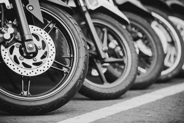 mopeds roller in einer reihe auf einer straße geparkt. - motorcycle in a row tire wheel stock-fotos und bilder