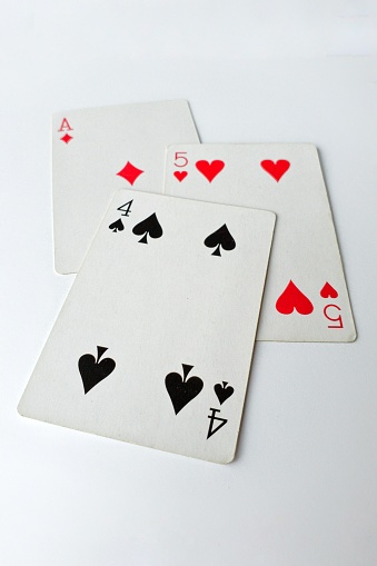 A vertical shot of three cards on a white table - card game, recreation